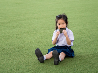 Fototapeta premium Happy Asian child eating delicious nori seaweed, in the garden