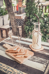 Breakfast . Iced fresh milk and Bread, butter beans . Placed on a wooden table ready to serve you for holidays . Customize colors Vintage retro and old film Tone . Coffee break