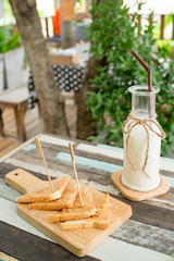 Breakfast . Iced fresh milk and Bread, butter beans . Placed on a wooden table ready to serve you for holidays . Customize colors Vintage retro and old film Tone . Coffee break