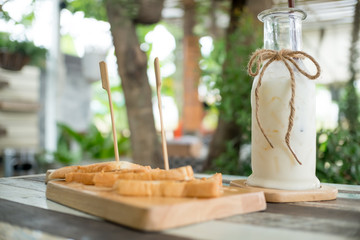 Fototapeta premium Breakfast . Iced fresh milk and Bread, butter beans . Placed on a wooden table ready to serve you for holidays . Customize colors Vintage retro and old film Tone . Coffee break