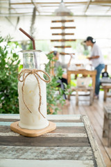 Breakfast . Iced fresh milk  Placed on a wooden table ready to serve you for holidays . Customize colors Vintage retro and old film Tone . Coffee break