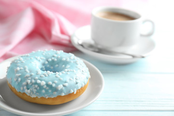Plate with donut and cup of coffee on background