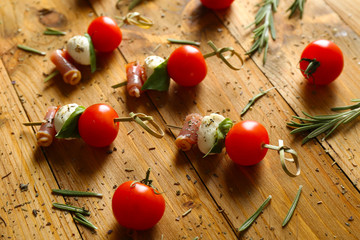 Set of delicious canapes with rosemary on wooden background