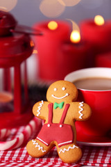 Composition of tasty gingerbread cookie and cup of coffee on kitchen table, close up view