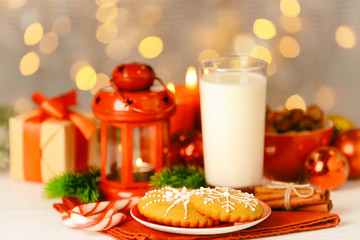 Composition of tasty gingerbread cookies and glass of milk on kitchen table