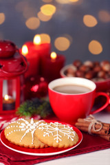 Composition of tasty gingerbread cookies and cup of coffee on kitchen table