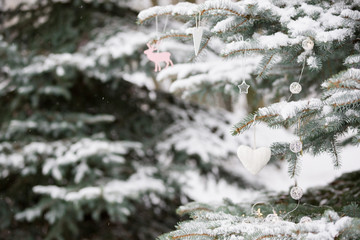 Nice decorations on a Christmas tree with snow outdoors. Celebration, winter and holidays concept