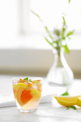 Citrus cocktail on table on blurred window background