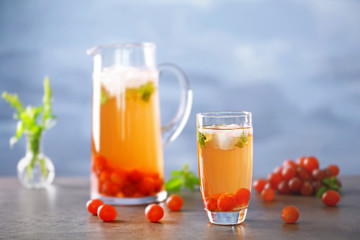 Cold grape cocktail and fresh berries on blurred background