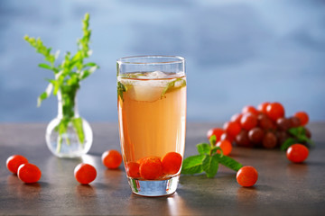 Cold grape cocktail and fresh berries on blurred background