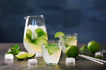 Fresh lime cocktail and ice cubes on table