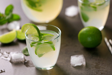 Fresh lime cocktail with ice cubes on grey background