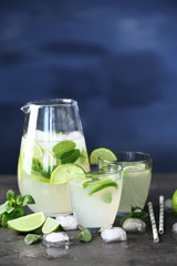 Fresh lime cocktail and ice cubes on table
