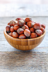 Brown hazelnuts in a wooden bowl.