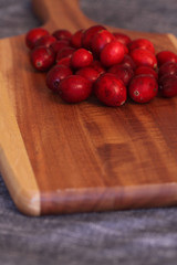 Cranberries on a wooden chopping board