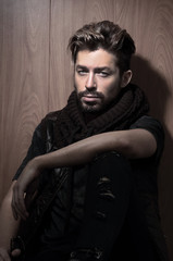 Obraz premium Portrait of young handsome fashionable man against wooden wall.