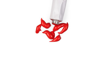 Bright red Acrylic paint, extruded from the tube. On a white background, close-up.