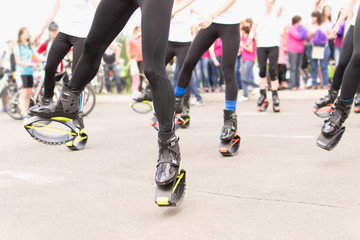 Obraz premium Women muscle body parts performing in cloudy day. Crowds of people watching