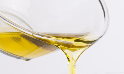 Olive oil flows from a glass bowl