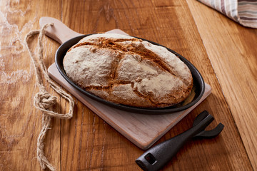 soda bread  on a oval cast iron pan over a wooden table