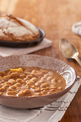 soda bread  on a oval cast iron pan and bean soup over a wooden table