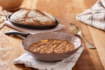soda bread  on a oval cast iron pan and bean soup over a wooden table
