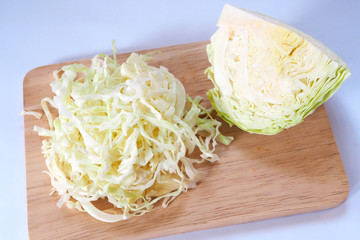 Close up of shredded cabbage on wooden cutting board.