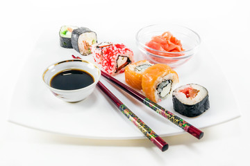 Different sushi rolls with chopsticks on white background