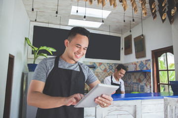 young male cafe owner with tablet