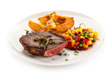 Grilled steak, baked potatoes and vegetable salad on white background 