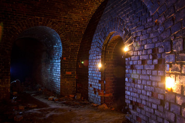 Dungeon under the old german fortress illuminated by lantern and candles