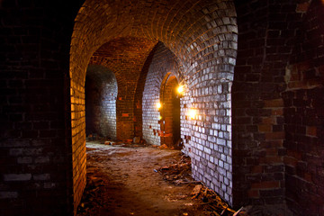 Dungeon under the old german fortress illuminated by lantern and candles