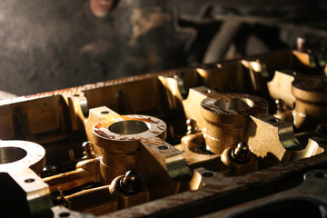 Open block of four cylinder petrol engine. The cylinder head in the workshop.