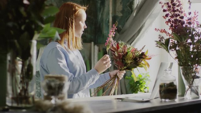cute ginger florist arranging bunch of flowers
