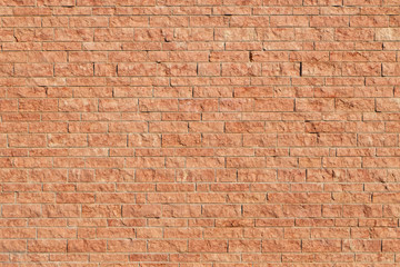 naturally red stone wall made of brick colored blocks