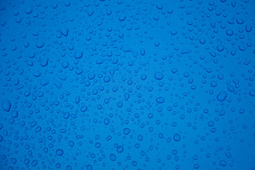 Rain drops on blue metal surface. Background and textures.