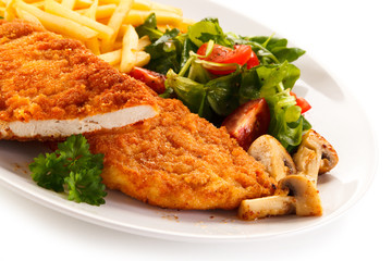 Fried pork chop, French fries and vegetables 