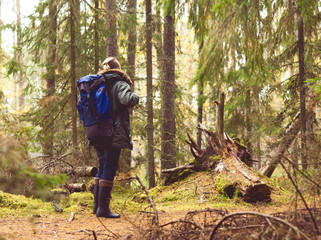 Young man with a backpack hiking in a forest