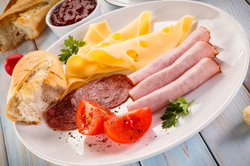 Breakfast - fried sausages, yellow cheese and vegetables 