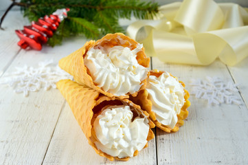 Crispy honey wafers in the form of cones, filled with air vanilla cream (ice cream) on a white background. Close-up. Treats for the party.