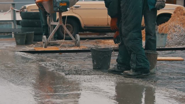 Pouring, Laying Concrete at the Construction Site using Buckets of Cement.