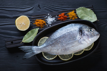 Above view of fresh uncooked dorado fish with various condiments