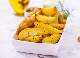 Ruddy Baked potato wedges with rosemary and garlic on a light background