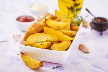 Ruddy Baked potato wedges with rosemary and garlic on a light background