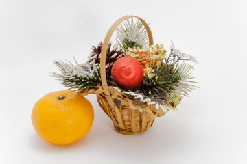 Christmas basket and one ripe tangerine isolated on white background
