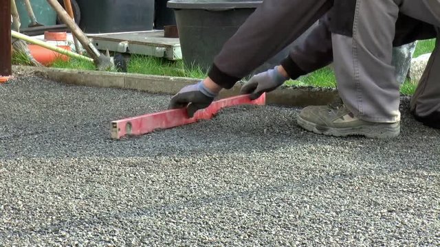 Bauarbeiter verlegt Pflastersteine
(Construction worker laying pavement rocks)
