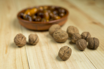 Dice and nuts on a background of pine wood.