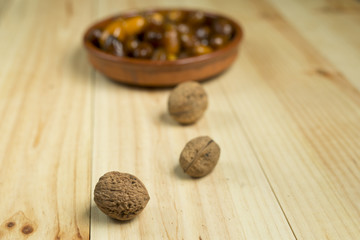 Dice and nuts on a background of pine wood.