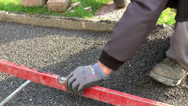 Bauarbeiter verlegt Pflastersteine
(Construction worker laying pavement rocks)