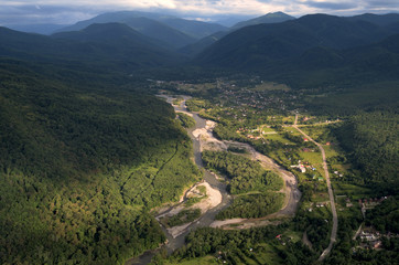 View of the mountain river and the village from a height. Summer